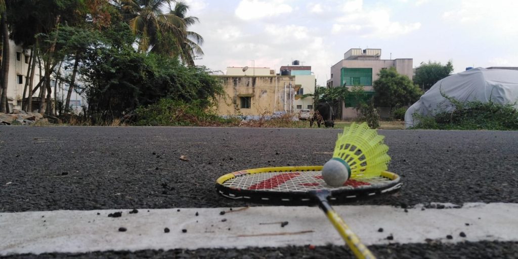Close-up of a racket's string bed with a plastic shuttlecock resting on it