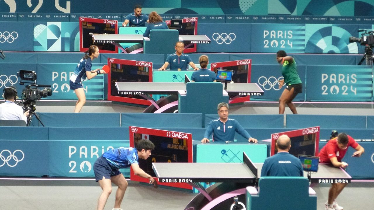 Tomokazu Harimoto and Martin Allegro playing a singles match at the Paris 2024 Olympic table tennis event