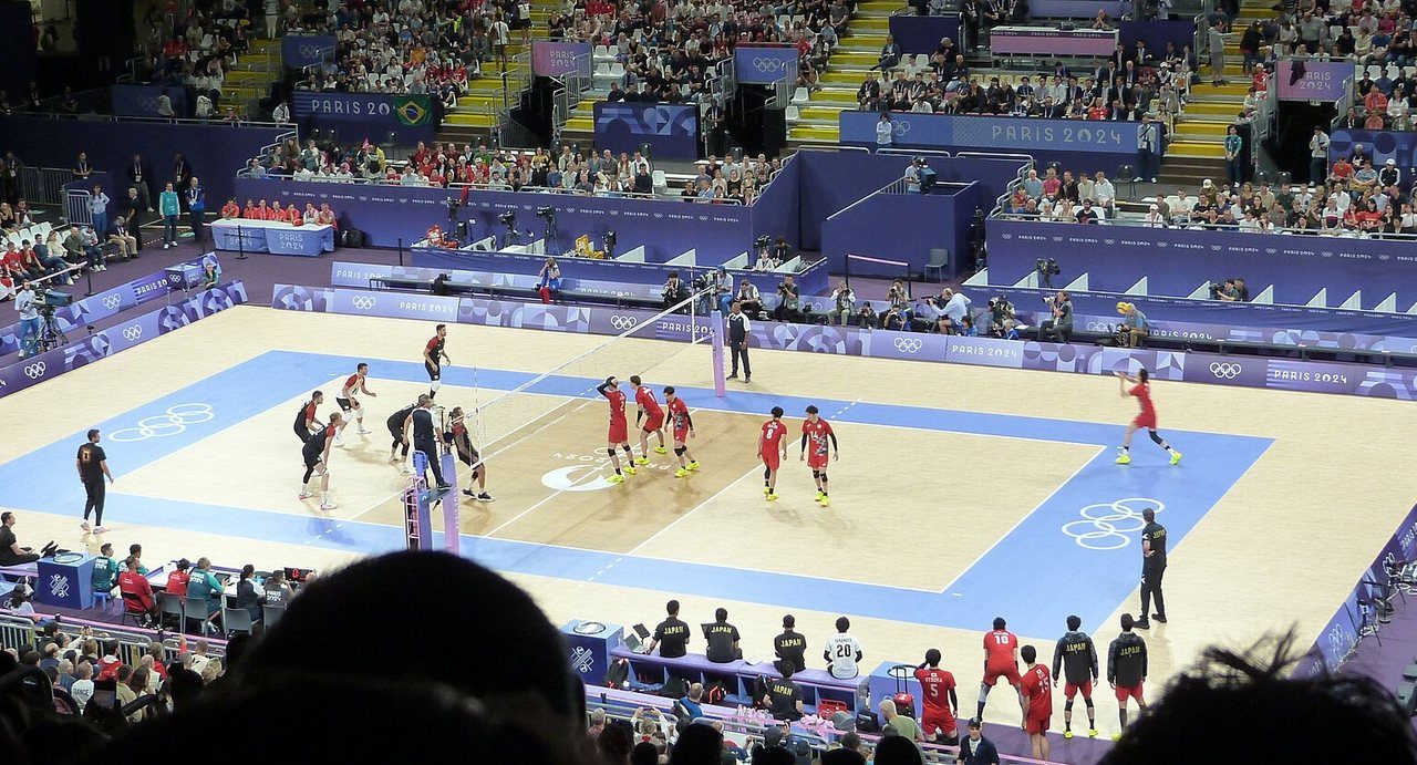Japan and Germany lined up on an indoor volleyball court at the Paris 2024 Olympics
